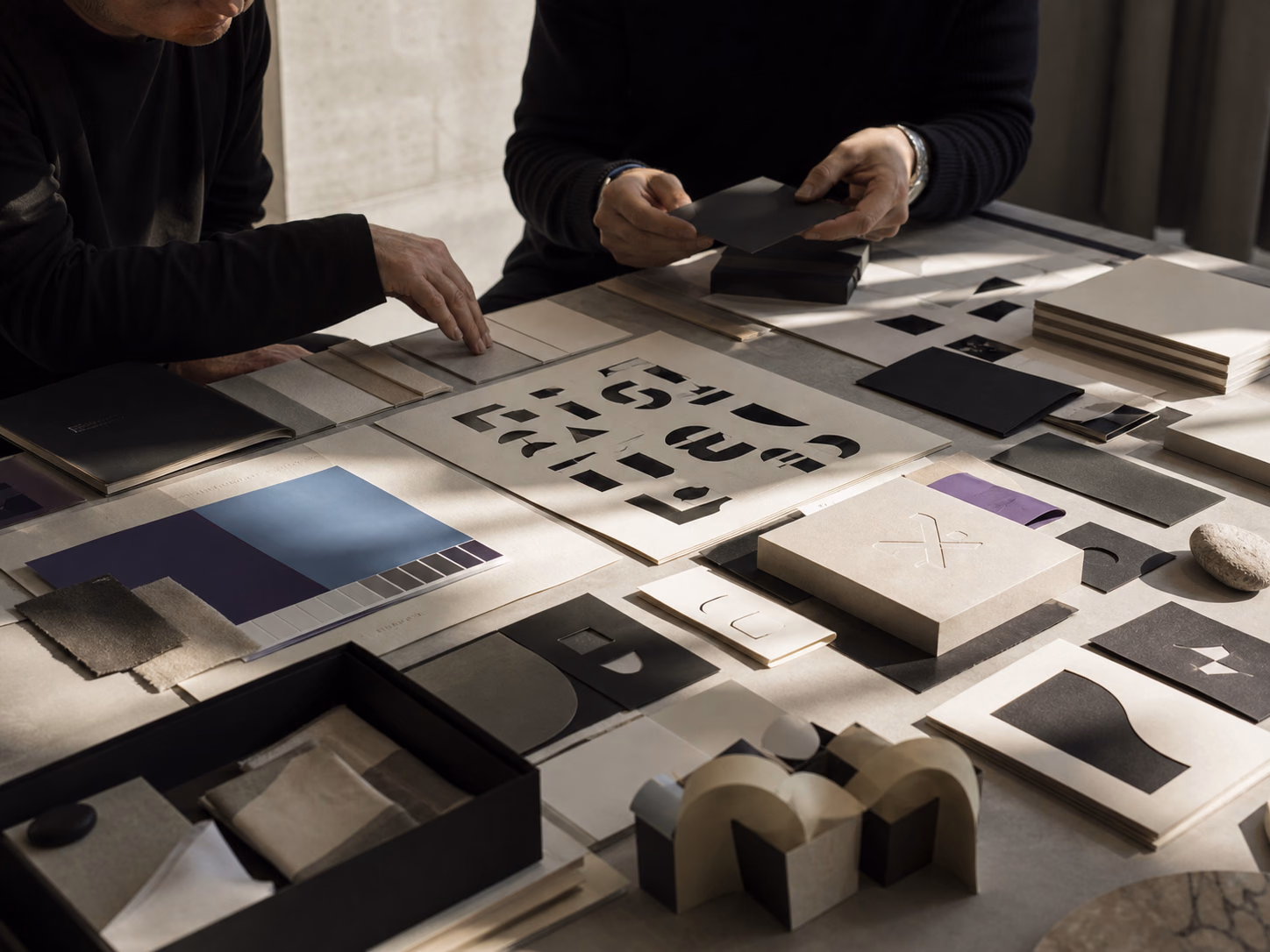 Mesa de branding con pruebas tipográficas, materiales y prototipos de empaque
